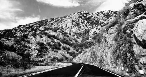 Road amidst trees against sky