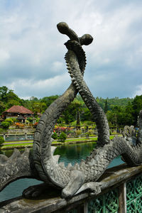 Statue by trees against sky