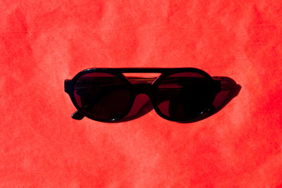 Close-up of sunglasses against red background