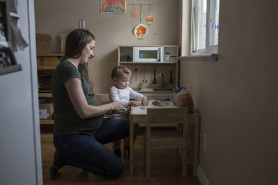 Pregnant mother and son playing with toys at home