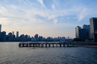 View of river and buildings against sky