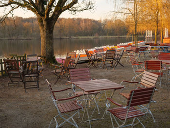 Empty chairs and tables in lake