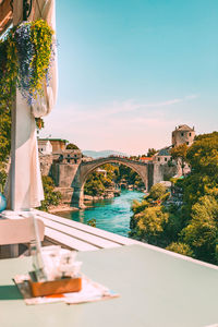 Arch bridge over river against sky