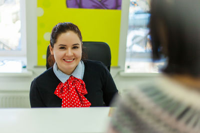 Portrait of smiling receptionist sitting in hotel