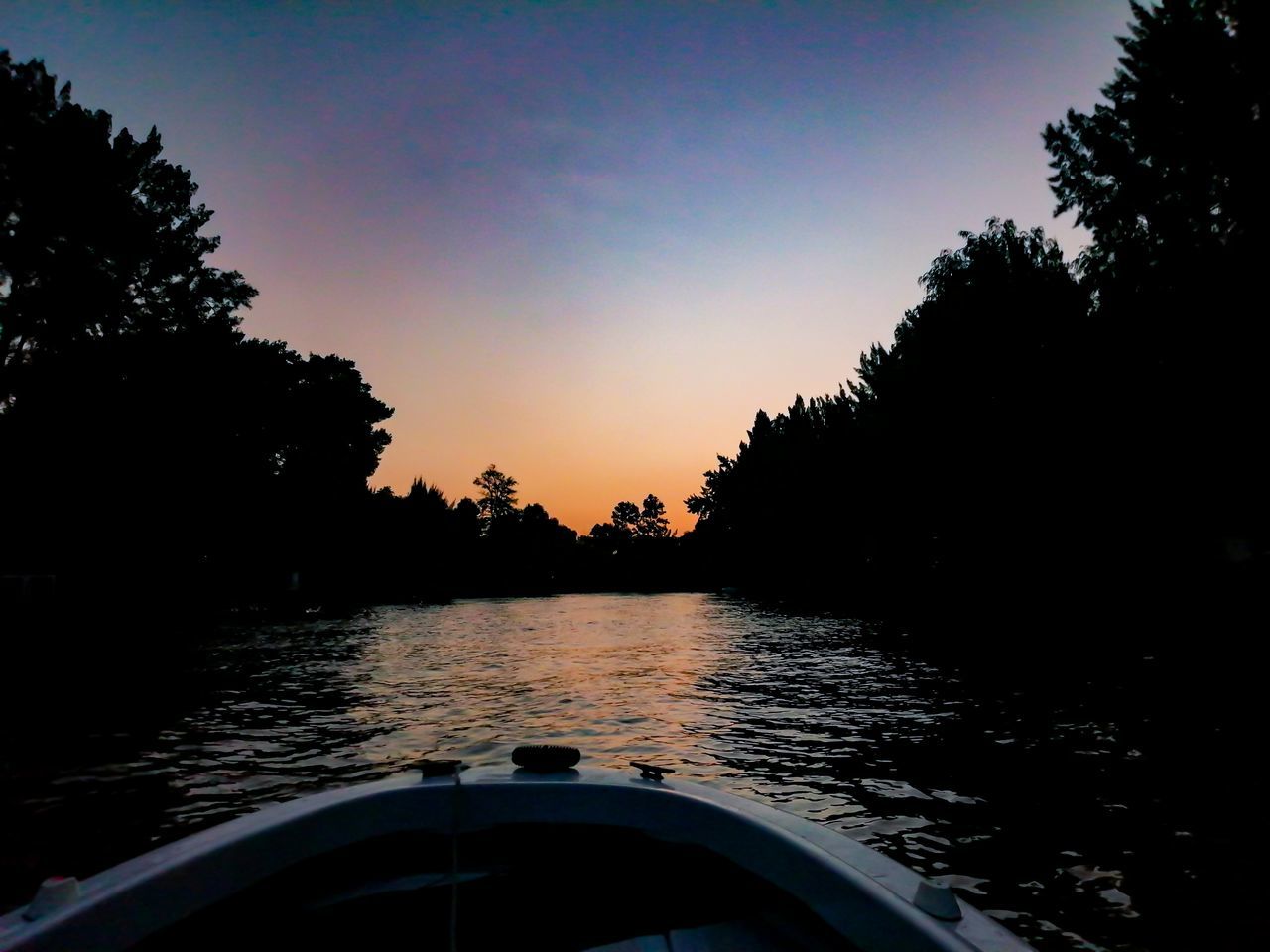 water, tree, sky, nature, transportation, plant, sunset, mode of transportation, boat, vehicle, beauty in nature, nautical vessel, scenics - nature, tranquility, evening, dusk, no people, tranquil scene, lake, outdoors, travel, reflection, silhouette, watercraft, cloud