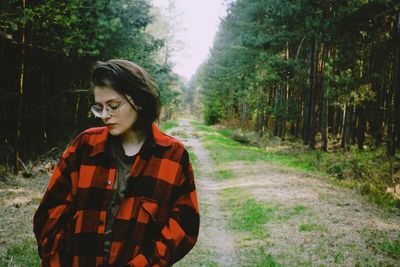 Young woman standing in forest