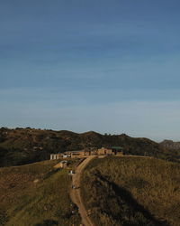 Road amidst field against sky