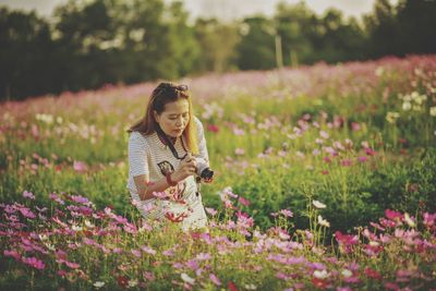 Woman holding flowers on field