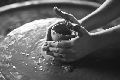 Cropped hands of woman making pot