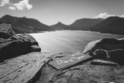 Close-up of text on rock against sky