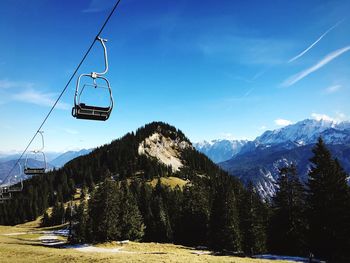 Overhead cable car over mountains against sky