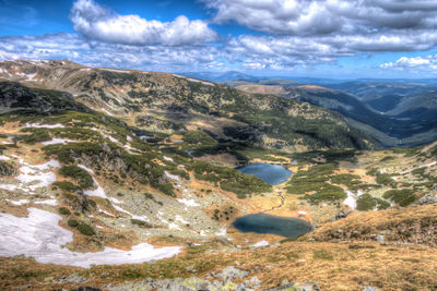 Scenic view of mountains against cloudy sky