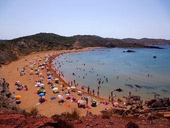 High angle view of people on beach against clear sky