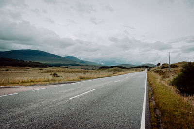 Empty road along countryside landscape