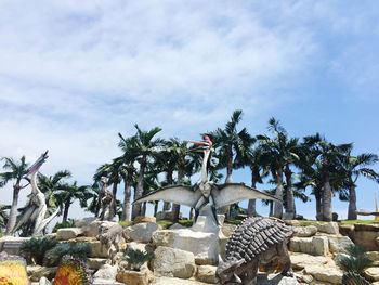 Palm trees and rocks against sky