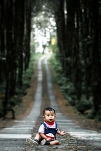 Full length of boy on footpath in forest