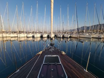 Sailboats moored at harbor against sky