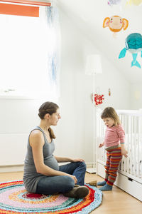 Pregnant woman with daughter at home