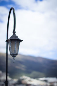 Close-up of illuminated lamp against sky