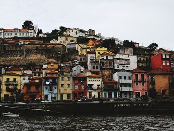 Residential buildings by river against sky