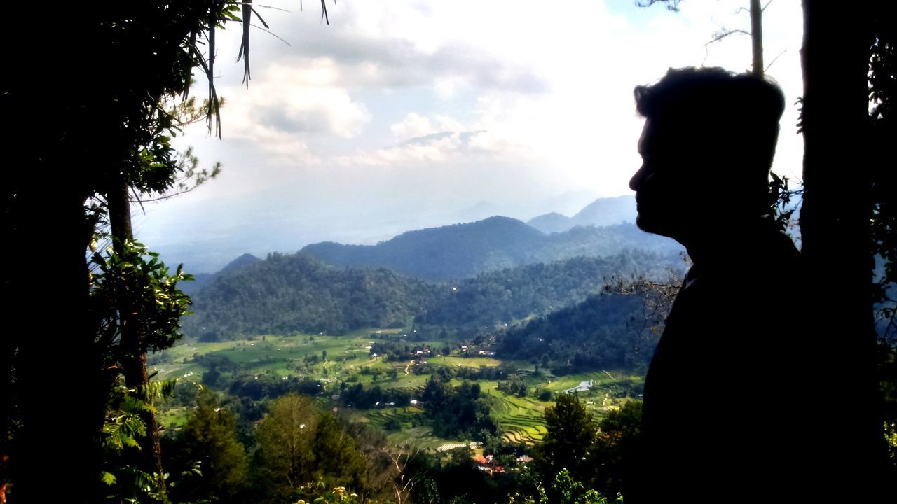 mountain, lifestyles, sky, tree, leisure activity, rear view, silhouette, landscape, tranquility, standing, scenics, men, nature, tranquil scene, beauty in nature, person, looking at view, cloud - sky