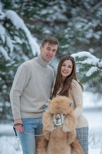 Portrait of smiling young woman with dog in forest