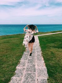 Rear view of woman standing on beach