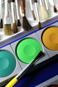 High angle view of color palette with paintbrushes on table