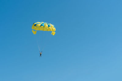 Low angle view of kite flying against clear blue sky