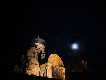 Low angle view of illuminated buildings against sky at night