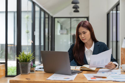 Young businesswoman using laptop at office