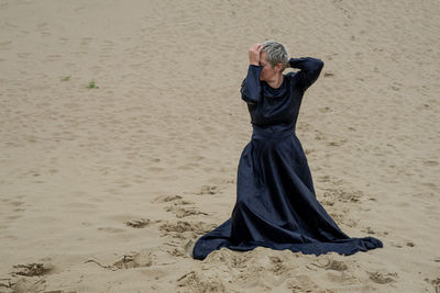 Midsection of woman on sand at beach