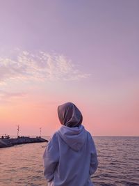 Rear view of woman on beach during sunset