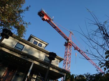 Low angle view of construction site against clear blue sky