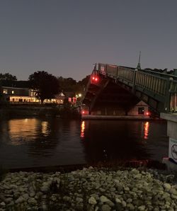 Bridge over river against sky at night