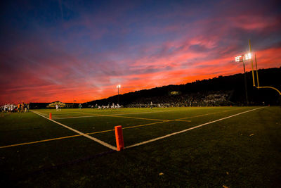 Soccer field against sky during sunset