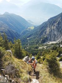 Scenic view of woman climbing rocks in a mountain at heini-holzer-klettersteig