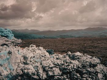 Scenic view of mountains against cloudy sky