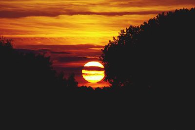 Scenic view of silhouette trees against romantic sky at sunset