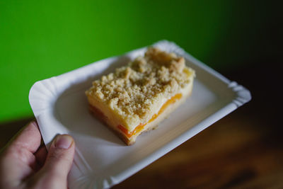 Close-up of hand holding bread in plate