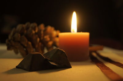 Close-up of burning candle on table