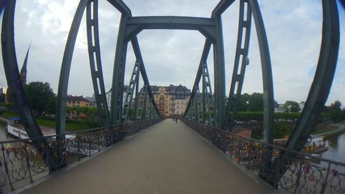 Footbridge against sky in city