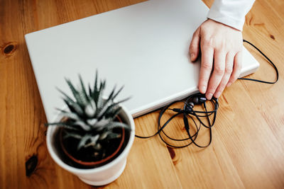 Cropped hand of woman with laptop