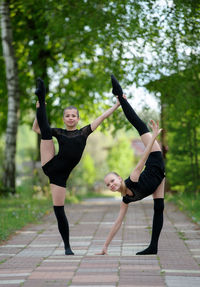 Portrait of smiling ballet dancers posing on footpath