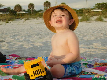 Happy baby boy playing at beach