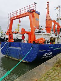 Ship moored at pier against sky