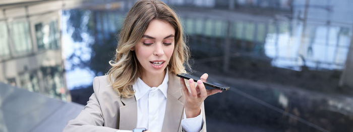 Young woman using mobile phone in city