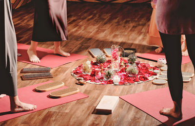 Women standing around candles and flower petals and ready to do sadhu board practice 