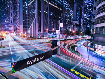 Light trails on city street by buildings at night