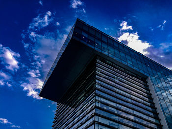 Low angle view of modern building against blue sky